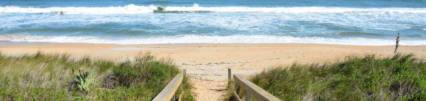 boardwalk leading to beach in st augustine florida with bright blue sky 